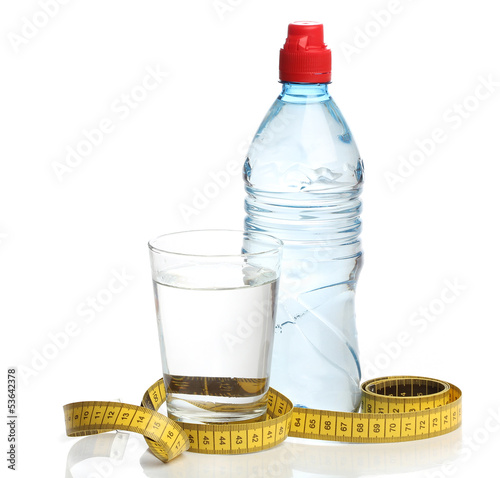Photo: Bottle with water and a measuring tape isolated Bottle with water and a measuring tape isolated
