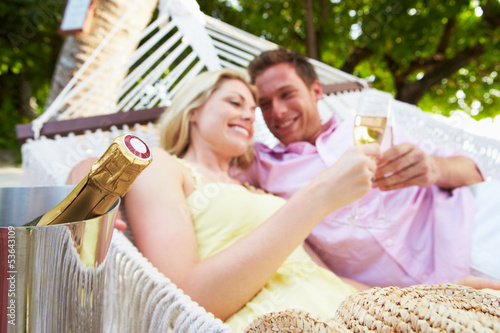 Photo: Couple Relaxing In Beach Hammock Drinking Champagne Couple Relaxing In Beach Hammock Drinking Champagne