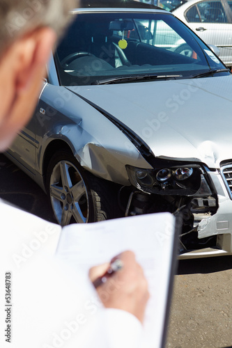 Photo: Loss Adjuster Inspecting Car Involved In Accident Loss Adjuster Inspecting Car Involved In Accident