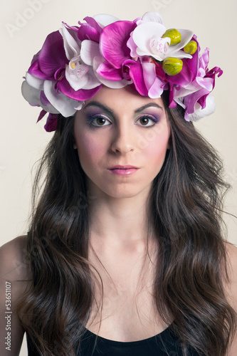 Photo: Close up portrait of beautiful girl with orchid pink flowers Close up portrait of beautiful girl with orchid pink flowers