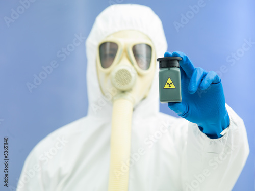 Photo: person in protective suit holding isotope sample person in protective suit holding isotope sample