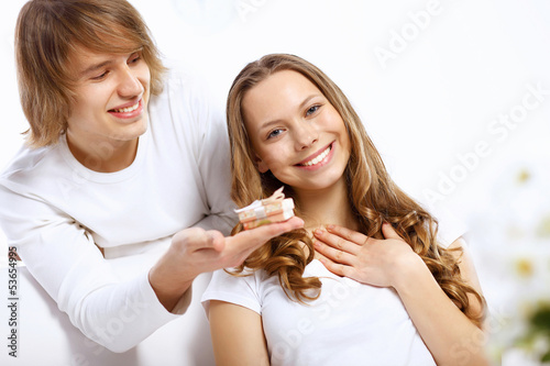 Photo: Young couple at home with present Young couple at home with present