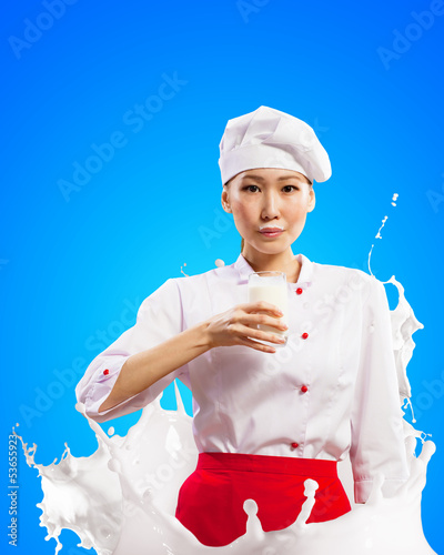 Photo: Asian female cook against milk splashes Asian female cook against milk splashes