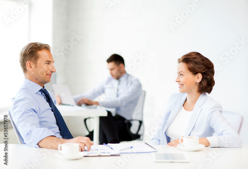 Photo: man and woman discussing something in office man and woman discussing something in office