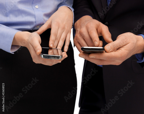 Photo: woman and man hands with smartphones woman and man hands with smartphones