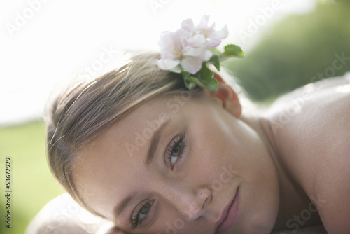 Photo: A young woman laying down with apple blossom in her hair A young woman laying down with apple blossom in her hair