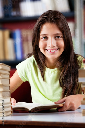 Photo: Happy Schoolgirl Sitting At Table In Library Happy Schoolgirl Sitting At Table In Library