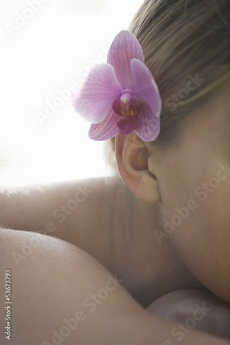 Photo: A young woman wearing a pink orchid in her hair A young woman wearing a pink orchid in her hair