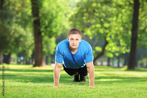 Photo: Young sportsman exercising in a park Young sportsman exercising in a park