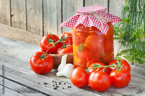 Photo: Homemade tomatoes preserves in glass jar. Fresh and canned tomat Homemade tomatoes preserves in glass jar. Fresh and canned tomat