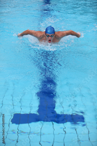 Photo: dynamic and fit swimmer performing the butterfly stroke dynamic and fit swimmer performing the butterfly stroke