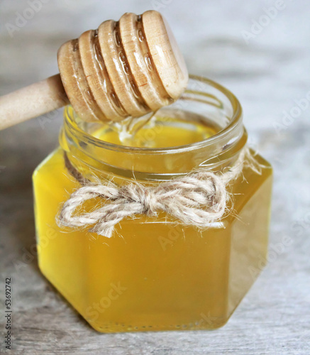 Photo: Jar of organic floral honey with a honey spoon Jar of organic floral honey with a honey spoon