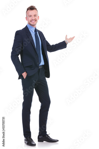 Photo: business man presents with hand in pocket business man presents with hand in pocket