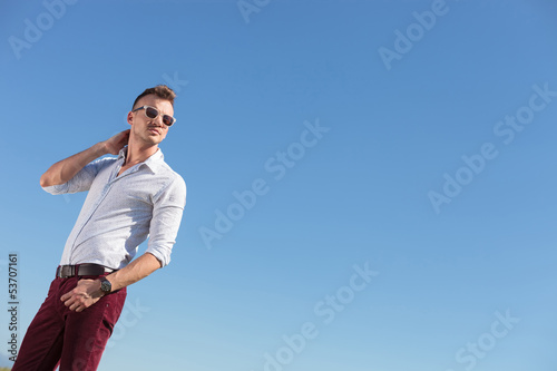 Photo: outdoor casual man looks away with hand in pocket outdoor casual man looks away with hand in pocket