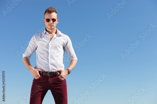 Photo: casual man with hands in pocket in front of blue sky casual man with hands in pocket in front of blue sky