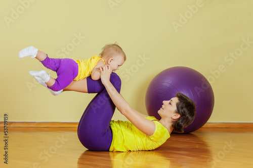 Photo: Mother do phisical exercises with her daughter at home Mother do phisical exercises with her daughter at home