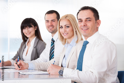 Photo: Business People Writing Meeting Notes Business People Writing Meeting Notes