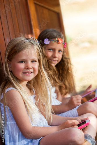 Photo: Two girls playing with digital devices. Two girls playing with digital devices.