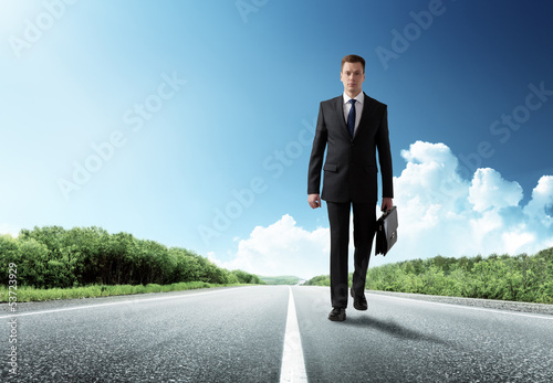Photo: business man walking on the road business man walking on the road