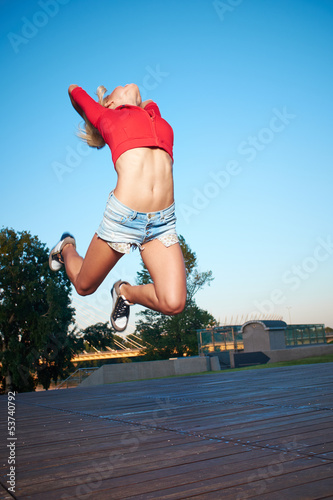 Photo: Athlete celebrating jumping and leaping against a night city. Athlete celebrating jumping and leaping against a night city.