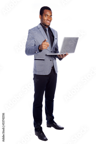 Photo: Smiling business man holding a laptop - isolated over a white ba Smiling business man holding a laptop - isolated over a white ba