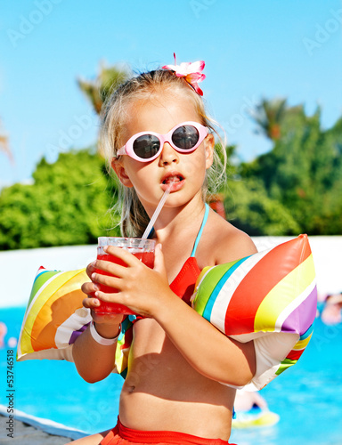 Photo: Child drinking near swimming pool. Child drinking near swimming pool.