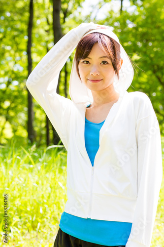 Photo: young asian woman relaxing in the park young asian woman relaxing in the park
