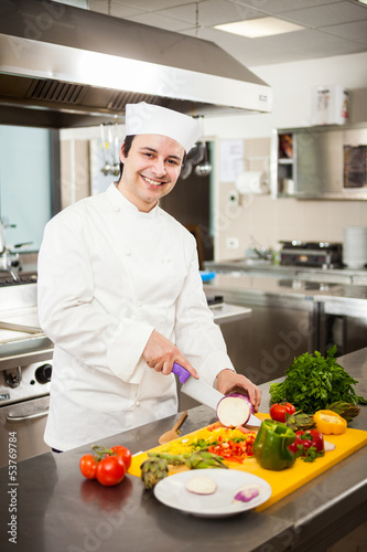 Photo: Friendly chef preparing vegetables in his kitchen Friendly chef preparing vegetables in his kitchen