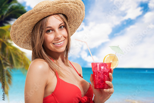 Photo: Woman drinking a cocktail on the beach Woman drinking a cocktail on the beach