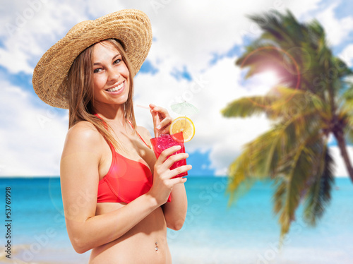 Photo: Woman drinking a cocktail on the beach Woman drinking a cocktail on the beach