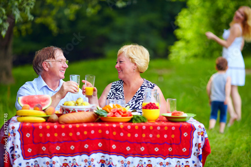 Photo: happy family having picnic outdoors happy family having picnic outdoors