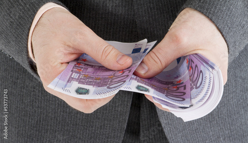 Photo: stack banknotes of 500 euro in male hands stack banknotes of 500 euro in male hands