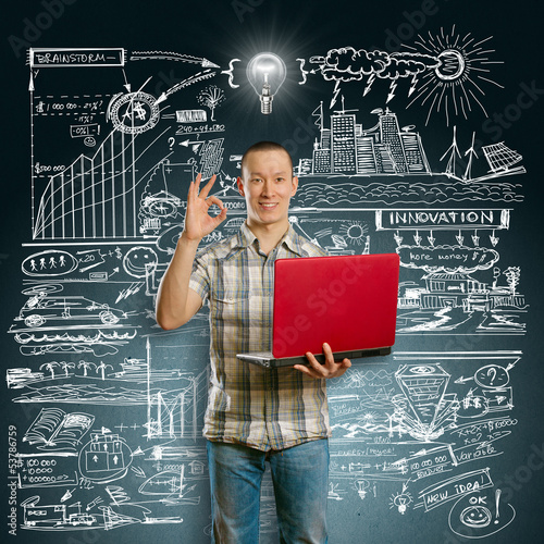 Photo: Idea Concept asian male with laptop in his hands shows OK Idea Concept asian male with laptop in his hands shows OK