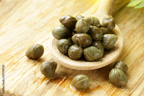 Photo: Pickled capers in a wooden spoon Pickled capers in a wooden spoon