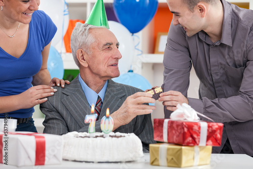 Photo: Senior man celebrating his birthday with family Senior man celebrating his birthday with family