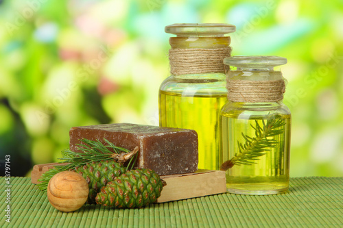 Photo: Hand-made soap and bottles of fir tree oil on bamboo mat Hand-made soap and bottles of fir tree oil on bamboo mat