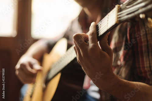 Photo: Creativity in focus. Close-up of men playing acoustic guitar Creativity in focus. Close-up of men playing acoustic guitar