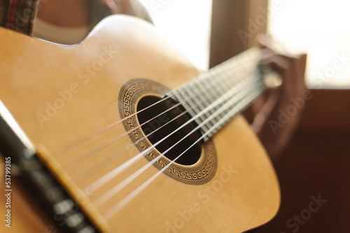 Photo: Close-up on the guitar. Close up of men playing acoustic guitar Close-up on the guitar. Close up of men playing acoustic guitar