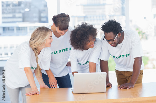 Photo: Smiling volunteers working together on a laptop Smiling volunteers working together on a laptop