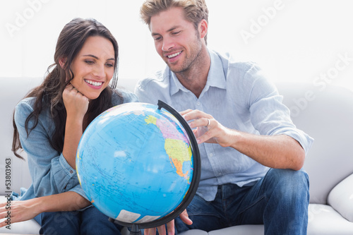 Photo: Couple looking at a globe Couple looking at a globe