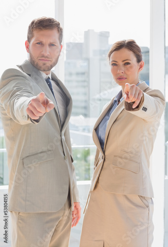 Photo: Serious business team pointing at camera Serious business team pointing at camera