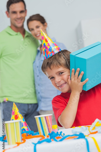 Photo: Little boy shaking his birthday gift Little boy shaking his birthday gift