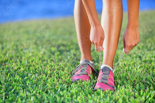 Photo: Running shoes - closeup of woman tying shoe laces Running shoes - closeup of woman tying shoe laces