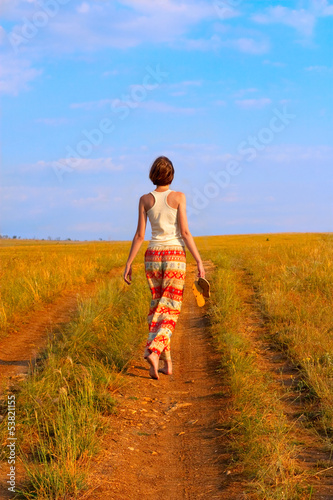 Photo: slender woman to walk on the earth road slender woman to walk on the earth road