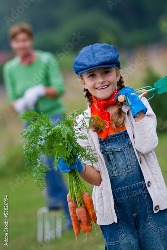 Photo: Gardening, vegetable - girl helping mother in the garden Gardening, vegetable - girl helping mother in the garden