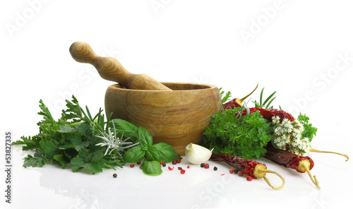 Wooden mortar and pestle with fresh herbs