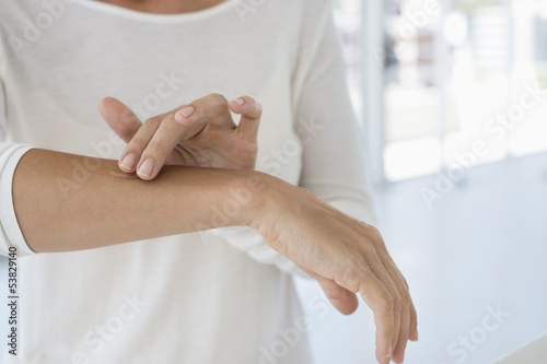 Photo: Woman applying ointment on her arm Woman applying ointment on her arm