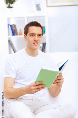 Photo: Young man at home with a book Young man at home with a book