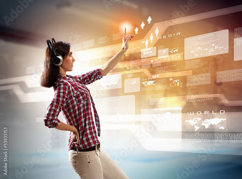 Photo: Woman touching virtual screen Woman touching virtual screen