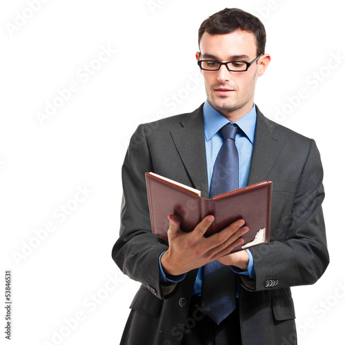 Photo: Businessman reading his agenda isolated on white Businessman reading his agenda isolated on white